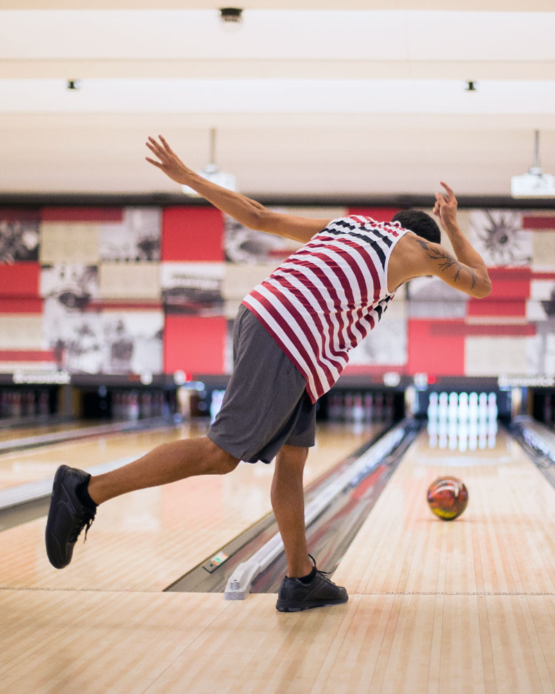 Four smiling friends holding bowling balls