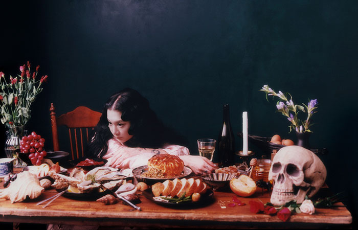 Woman leaning on a table full of food and decor Photo